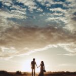 silhouette photo of man and woman under clear blue sky