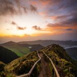 Mountain path with wooden fence at sunset